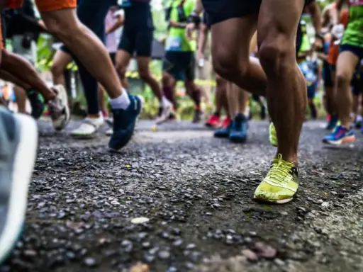 Läufer auf einer Strecke, die die halbmarathon distanz bewältigen. Fokus auf die Beine und Laufschuhe.