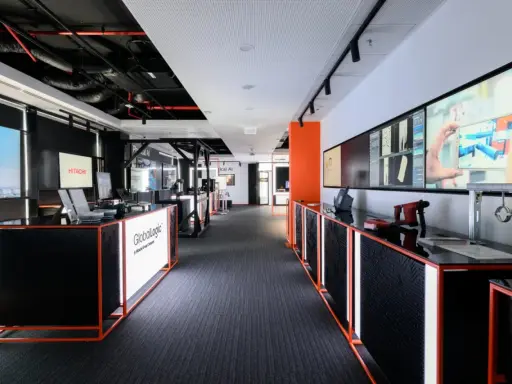 Nowoczesne biuro GlobalLogic, firmy z grupy Hitachi, z ekranami prezentującymi technologie.