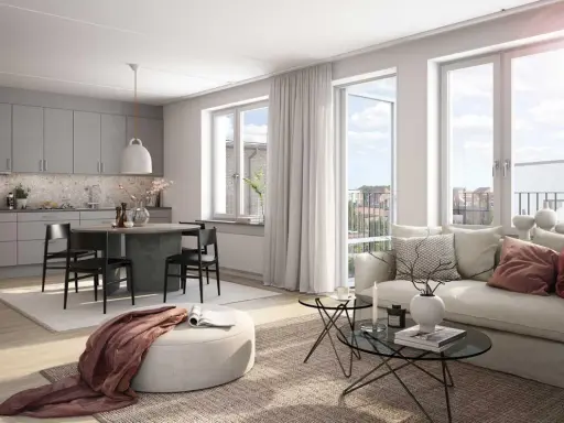 A bright, modern living room and kitchen with a dining table, sofa, and large windows.