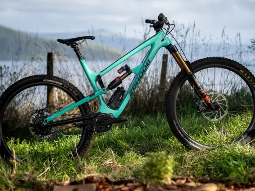 Turkusowy rower full-suspension marki Zerode, gotowy na górskie trasy. Wśród wielu marek rowerów, ten wyróżnia się designem.