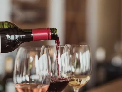 Rödvin hälls upp i glas under en vinprovning i Skåne. Rosé och vitt vin syns också.