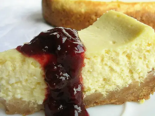 Pyszny sernik z serka wiejskiego polany wiśniową konfiturą, na kruchym spodzie.
