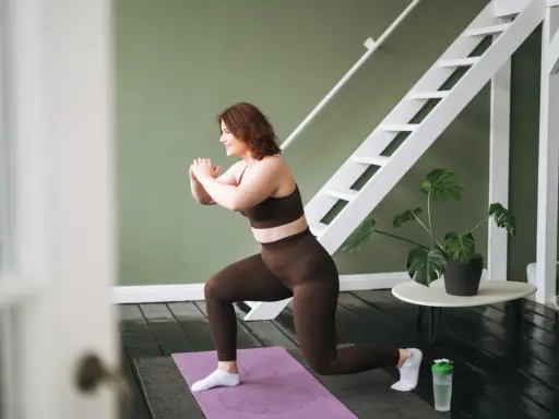 Frau macht Ausfallschritte auf einer Matte. Ihr **Crossfit zuhause**-Workout ist im vollen Gange, mit einer Leiter und einer Pflanze im Hintergrund.