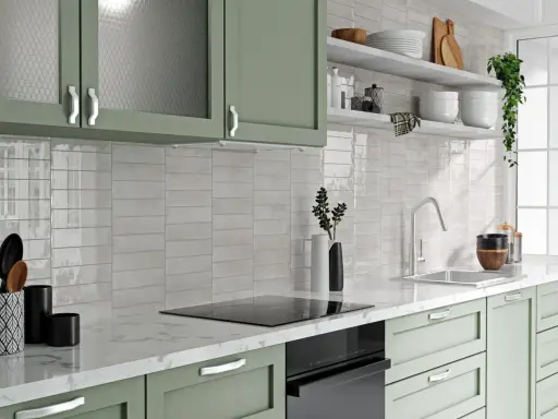 Jasne, błyszczące płytki między szafkami w kuchni dodają elegancji.