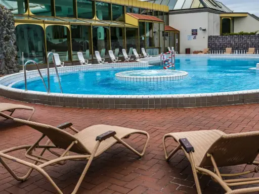 Entspannung pur an der Niederrhein Therme Mattlerbusch: Liegestühle laden zum Verweilen am blauen Pool ein.