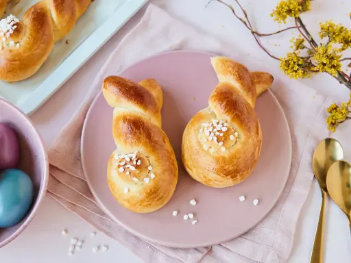 Zwei goldbraune Hefehasen mit Zuckerkristallen, bereit zum Osterfrühstück. Das Backen von Hefehasen ist eine schöne Tradition.