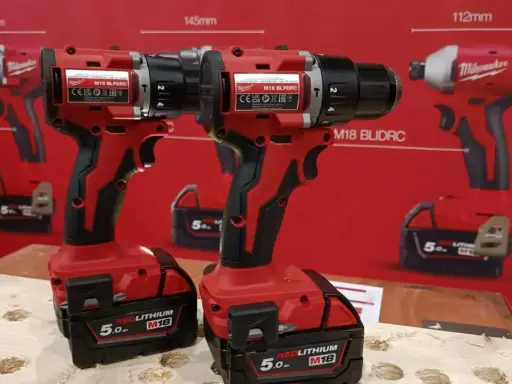 Dos taladros Milwaukee rojos y negros, parte de las marcas alemanas de herramientas, con baterías REDLITHIUM M18.