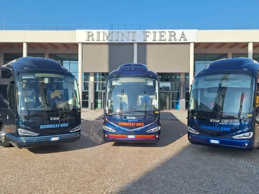 Tre bus Bonelli Bus blu scuro pronti per il viaggio da Rimini a San Marino, con la scritta "Rimini Fiera" sullo sfondo.