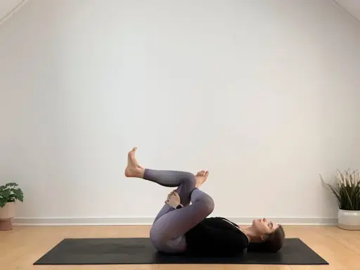 Frau in Yoga-Pose auf Matte, entspannt während ihrer Yoga-Periode.