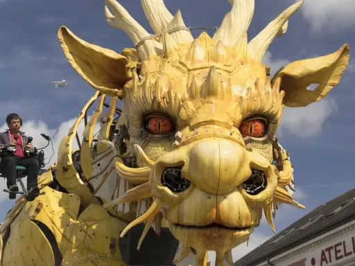 Ein Mann steuert eine riesige Holzdrachen-Skulptur, deren Augen bedrohlich glühen. Die Szene wirkt wie eine Warnung vor drakonischen Strafen, während ein Flugzeug am Himmel vorbeizieht.