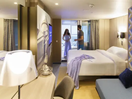Coppia in una moderna cabina interna di Costa Crociere. Letto matrimoniale, decorazioni artistiche e un balcone invitano al relax.