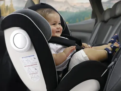 Bebé sonriente en silla de coche, grupo 0 hasta 18kg. Viaje seguro para los más pequeños.