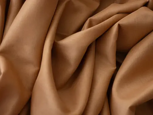 Tessuto in crepe color caramello, ideale per abiti eleganti, sia estivi che invernali, grazie alla sua caduta fluida.