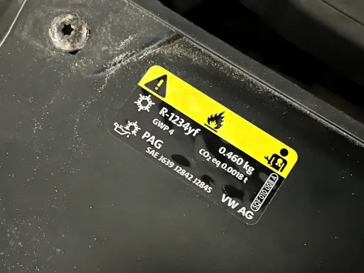 Naklejka informuje, jaki gaz do klimatyzacji samochodowej: R-1234yf, 0.460 kg. Zawiera też oznaczenie PAG.