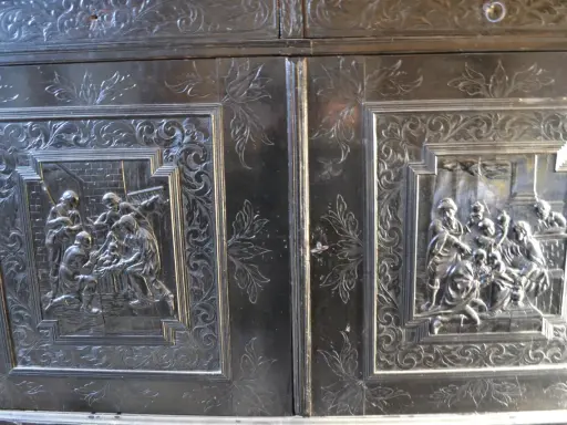 Détail d'un meuble Louis XIII sculpté de scènes bibliques et de motifs floraux.
