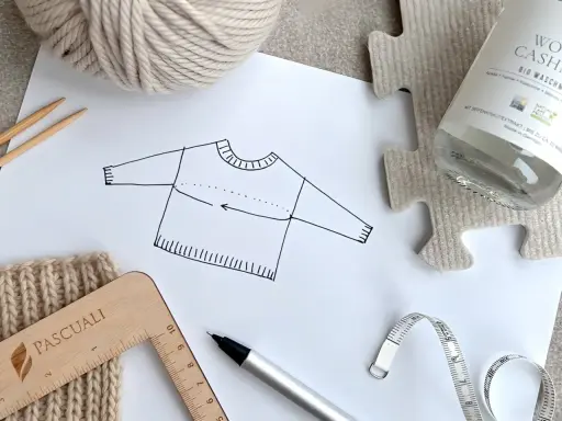 Esquema de jersey con medidas, ovillo de lana, agujas, cinta métrica y regla. Ideal para un top crochet tutorial.