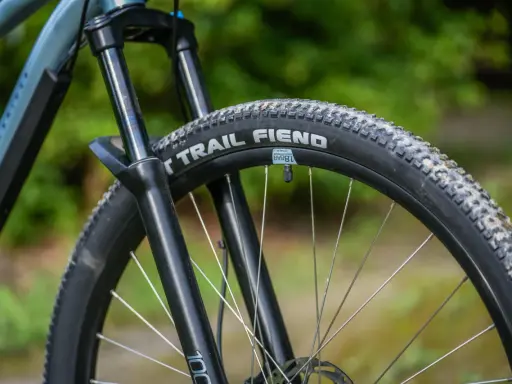 Opona rowerowa "Trail Fiend" z widocznym bieżnikiem, zwijana, gotowa na terenowe wyzwania.
