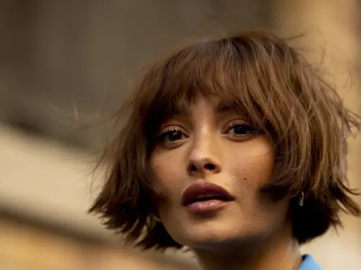 Eine Frau mit braunen, kurz geschnittenen Haaren und einem leichten Pony. Ein moderner Look, der durch das Damen Haare schneiden perfektioniert wurde.