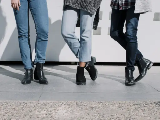 Trzy pary butów do jeansów: czarne botki na obcasie, zamszowe botki na grubej podeszwie i eleganckie czarne sztyblety.