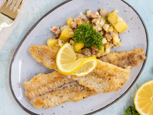 Gebratene Seelachsfilets mit Kartoffelsalat und Zitrone. Leckere Seelachsfilet Rezepte Pfanne für ein schnelles Abendessen.