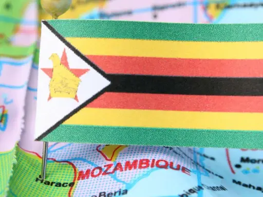 Flaga Zimbabwe na mapie, symbolizująca trudności gospodarcze i inflację.
