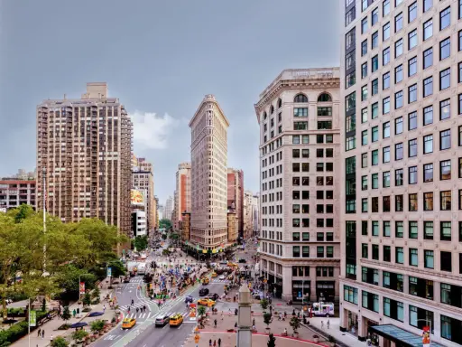 Vista aérea de Nueva York con el icónico edificio Flatiron en el centro. Los planos de la ciudad muestran la intersección de calles y la arquitectura circundante.