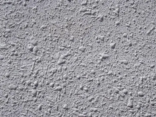 Textura gris de pared con relieve irregular, típica del **el gotelé**, que crea un efecto rugoso y con pequeñas protuberancias.