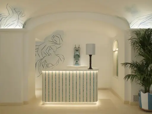 L'entrée art déco dévoile une réception lumineuse, ornée de fresques murales et d'une plante luxuriante.