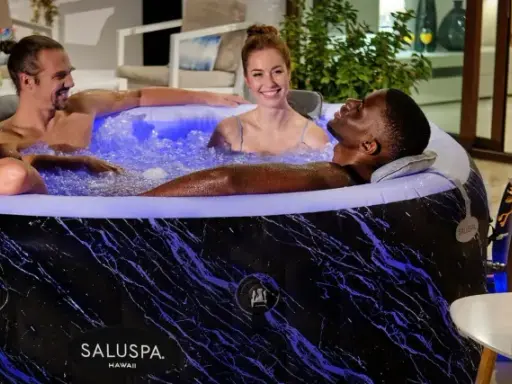 Quatre amis profitent d'un moment de détente dans un spa gonflable, illuminé de bleu. L'entretien de ce spa gonflable est simple pour des moments de pur bonheur.