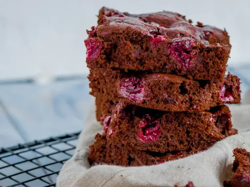 Ein Stapel saftiger Schoko Kirsch Kuchen Blech Stücke mit saftigen Kirschen.