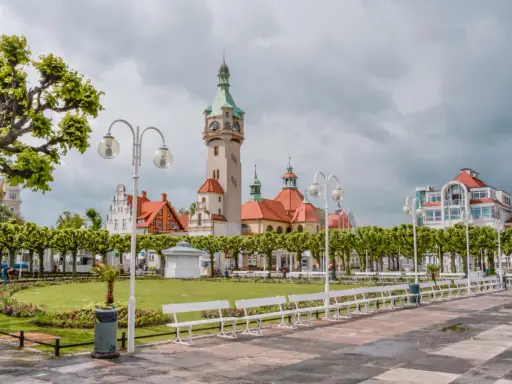Malowniczy widok na deptak w Sopocie, z charakterystyczną wieżą i budynkami w stylu secesyjnym. Idealne miejsce na spacer między Gdańskiem a Gdynią.