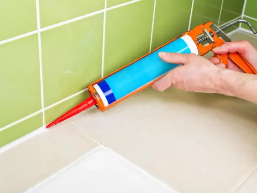 Application de silicone pour maçonnerie sur un joint de carrelage.