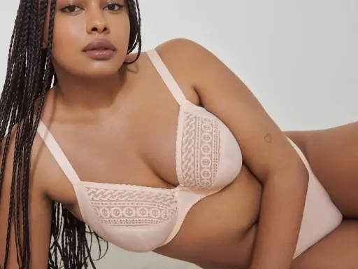 Modello con trecce indossa un reggiseno color pesca con pizzo. La taglia 4b reggiseno a cosa corrisponde?