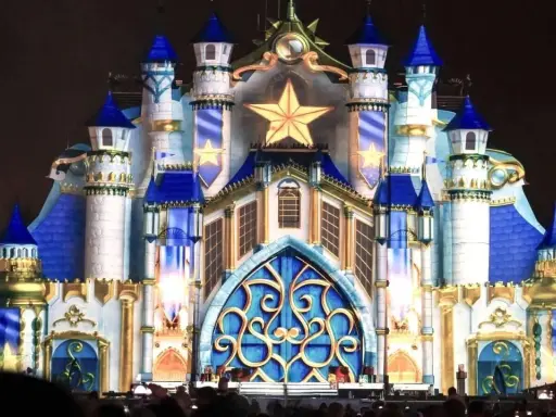 Castillo iluminado con estrellas doradas y detalles azules, evocando la magia de las **parques mágicas navidades**.