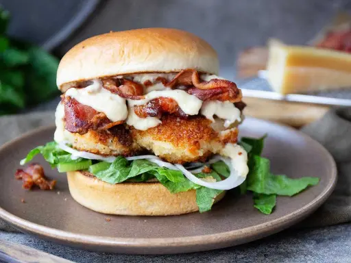 En saftig kycklingburgare med krispigt bacon, sallad, lök och en krämig dressing. Perfekt för ett gott hamburgerdressing recept.