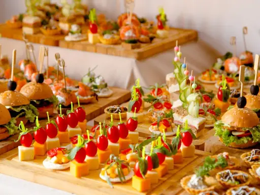 Deliciosos entrantes para boda: mini hamburguesas, canapés de salmón, brochetas de tomate y queso, y tartas saladas.