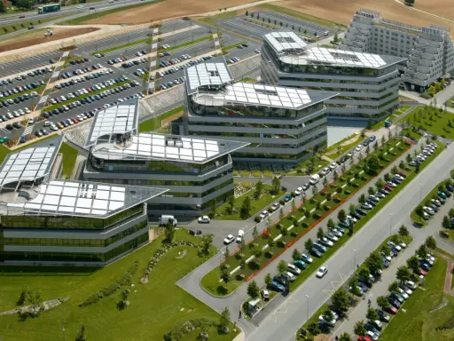 Vue aérienne de bâtiments modernes avec des parkings. On imagine un déjeuner d'affaires au restaurant La Javette.