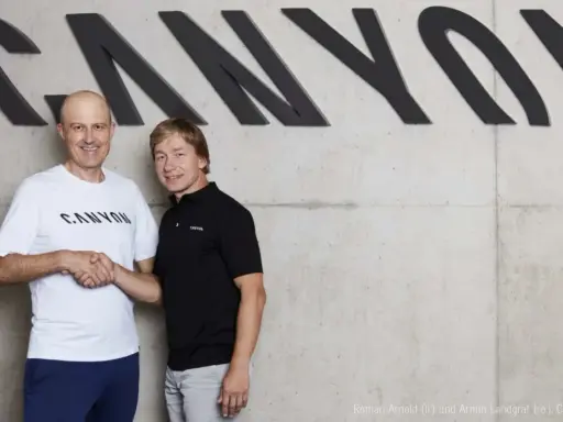Roman Arnold und Armin Landgraf schütteln sich die Hände vor dem Canyon-Logo.