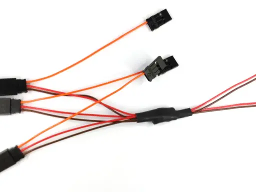 Ein dreiadriges Kabel mit mehreren schwarzen Steckern und bunten Leitungen, das für elektrische Verbindungen verwendet wird.