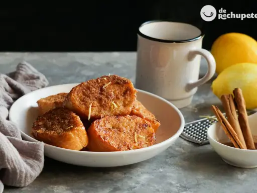 Torrijas de pan doradas y crujientes, espolvoreadas con ralladura de limón. Un clásico de las recetas de torrijas de pan, perfecto para disfrutar.