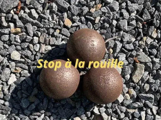 Trois boules de pétanque rouillées sur des graviers. Apprenez comment nettoyer des boules de pétanque pour qu'elles retrouvent leur éclat.