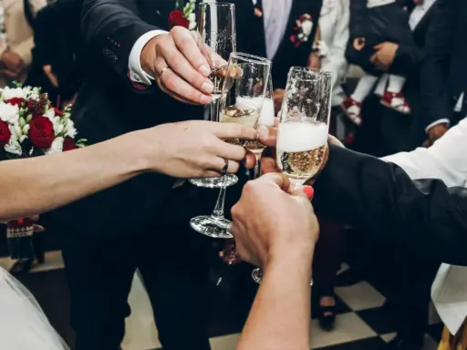 Wznoszenie toastów szampanem na weselu. Ile alkoholu na wesele? Kluczowe pytanie dla udanej zabawy!