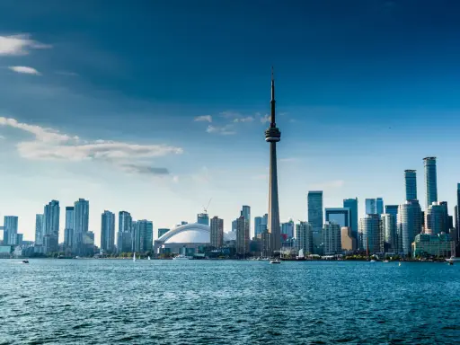 Widok na Toronto z wieżą CN i nowoczesnymi wieżowcami. Marzenie o locie do Warszawy w tle.