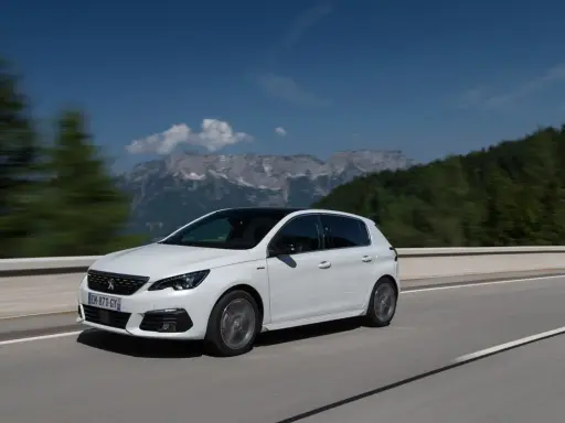 Blanco Peugeot 308 con motor 1.5 BlueHDi 100cv en carretera, con montañas al fondo. ¿Problemas?