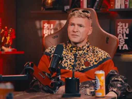 Mężczyzna w kurtce w panterkę, z blond włosami, siedzi w fotelu. Na półce za nim figurki Iron Mana. Wiek majora SPZ.