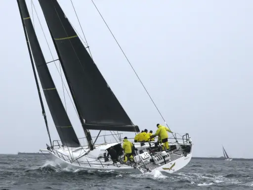 Segelboot mit gelber Crew bei einem spannenden ocean race.