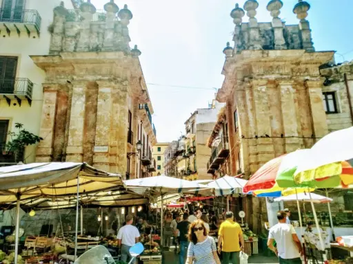 Mercato vivace a Palermo, tra bancarelle colorate e antiche architetture. Un'ottima idea per le cose da fare a Palermo, tra sapori e storia.