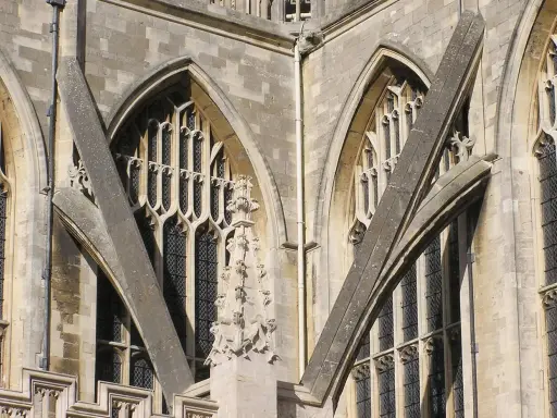 Detalle arquitectónico de una catedral gótica, mostrando la intrincada red de contrafuertes y arbotantes que sostienen sus imponentes muros y ventanas.