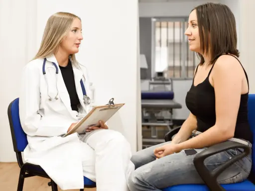 Medico parla con paziente, discutendo di tumori in giovani. Speranza e supporto in un momento difficile.