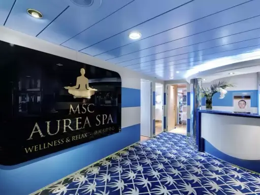 Ingresso della MSC Aurea Spa, con un'insegna dorata su sfondo nero e un tappeto blu con motivi bianchi.